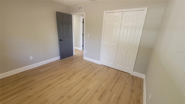 unfurnished bedroom with a closet and light wood-type flooring