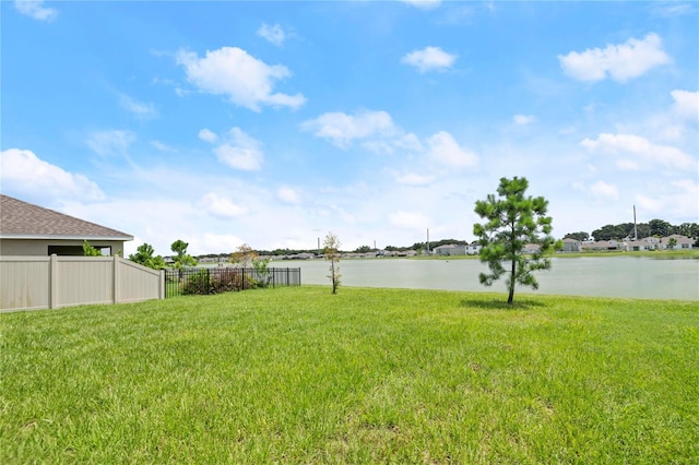 view of yard featuring a water view and fence