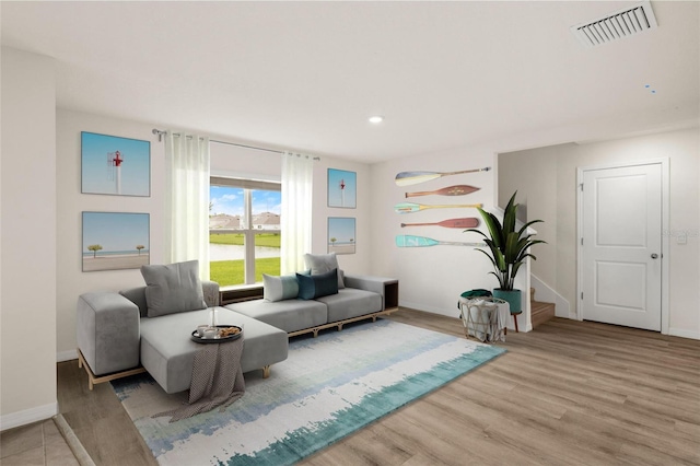 sitting room featuring baseboards, visible vents, wood finished floors, stairs, and recessed lighting