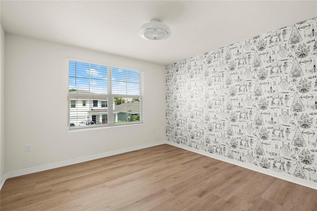 empty room with baseboards and wood finished floors