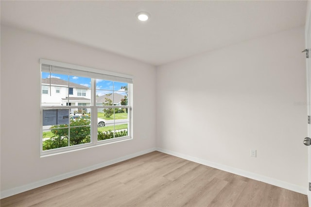 spare room featuring recessed lighting, light wood-style flooring, and baseboards