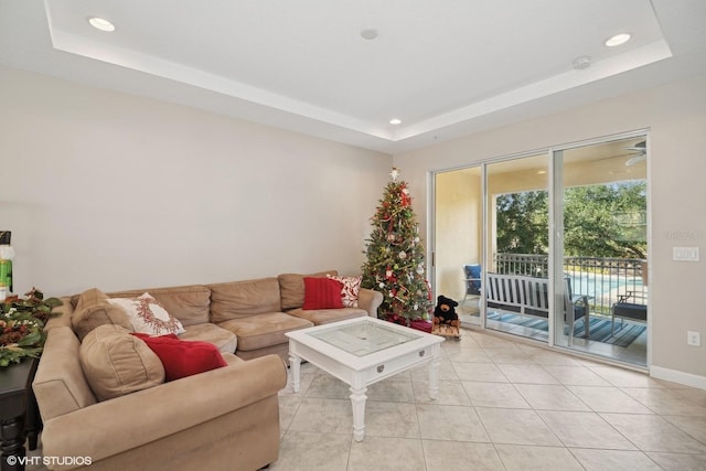 living room with light tile patterned floors and a raised ceiling