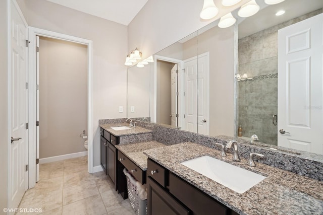 bathroom featuring tile patterned floors, a shower with door, vanity, and toilet