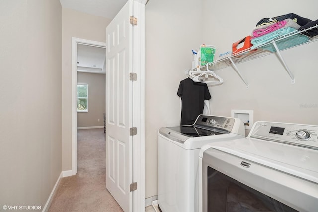 laundry area featuring separate washer and dryer and light carpet