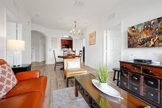 living room featuring light hardwood / wood-style floors and a notable chandelier