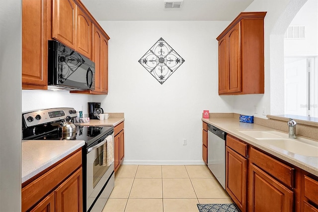 kitchen with light tile patterned floors, stainless steel appliances, and sink