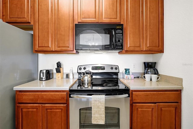 4814 Cayview Ave Unit 40613, Orlando, FL 32819 - kitchen featuring appliances with stainless steel finishes, light countertops, and brown cabinets