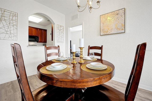 dining room featuring an inviting chandelier and light hardwood / wood-style flooring