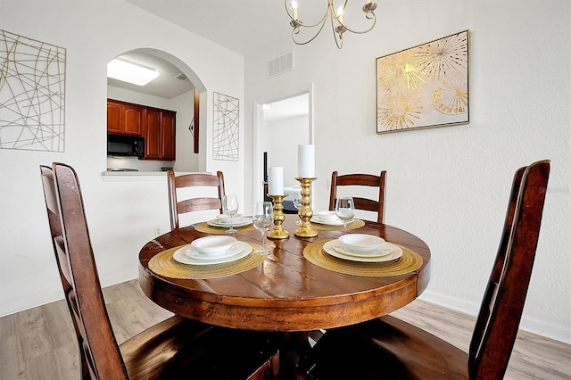4814 Cayview Ave Unit 40613, Orlando, FL 32819 - dining area with light wood-style floors, arched walkways, and a chandelier