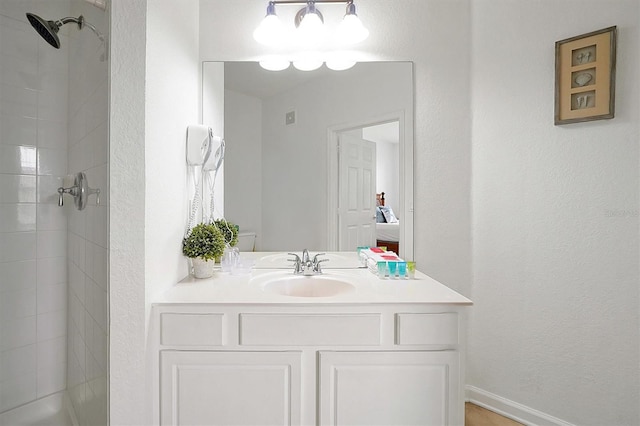 bathroom featuring vanity, toilet, and a tile shower