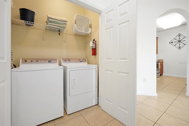 4814 Cayview Ave Unit 40613, Orlando, FL 32819 - laundry room featuring light tile patterned flooring, washing machine and dryer, and arched walkways