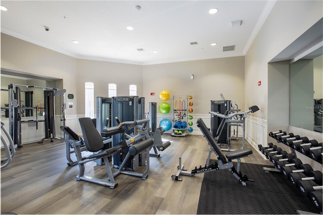 gym featuring hardwood / wood-style floors and crown molding