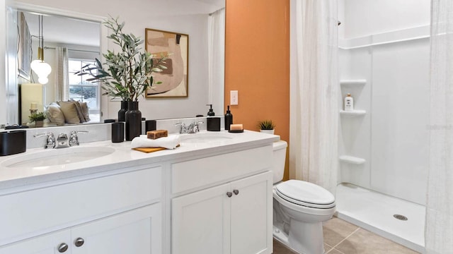 bathroom with tile patterned floors, toilet, vanity, and walk in shower