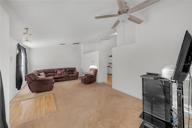 carpeted living room with ceiling fan, lofted ceiling, and a textured ceiling