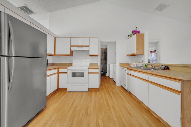 kitchen with white appliances, light hardwood / wood-style floors, white cabinetry, and lofted ceiling