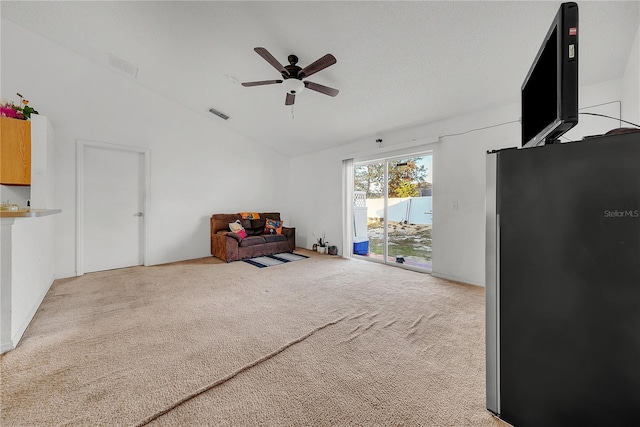 sitting room with ceiling fan, light colored carpet, and lofted ceiling