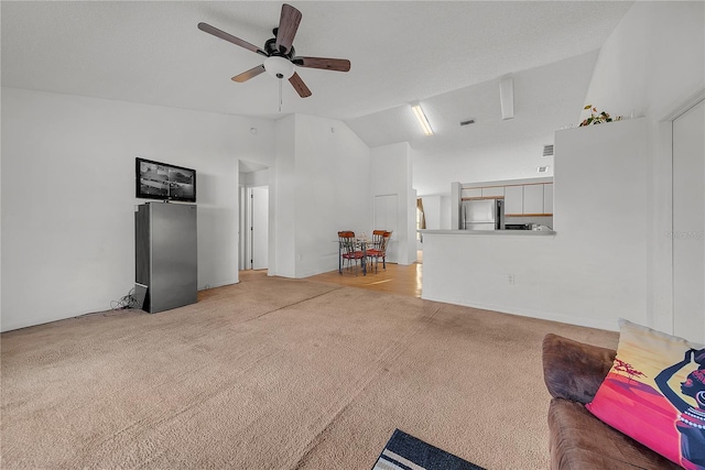 unfurnished living room featuring light carpet, ceiling fan, and lofted ceiling