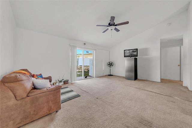 carpeted living room with ceiling fan and vaulted ceiling