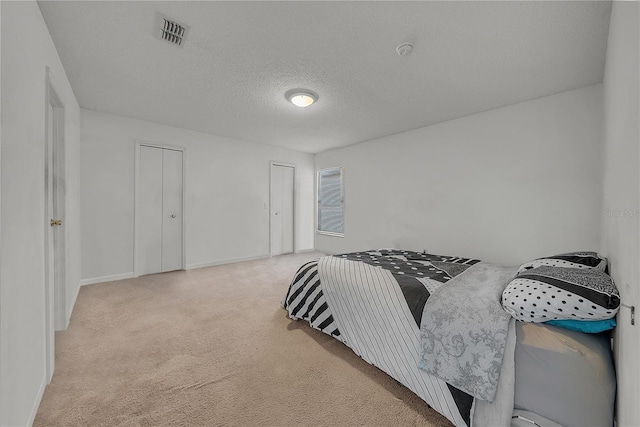 carpeted bedroom with a closet and a textured ceiling