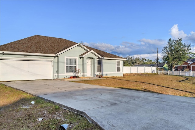 ranch-style house featuring a front yard and a garage