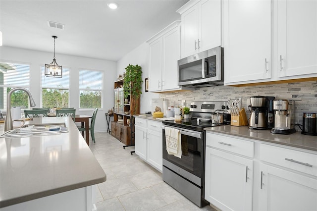 kitchen featuring decorative backsplash, sink, white cabinets, and appliances with stainless steel finishes