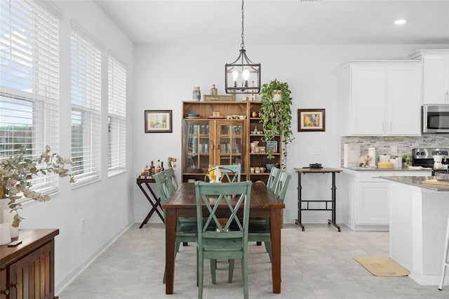 dining space with an inviting chandelier, baseboards, and recessed lighting