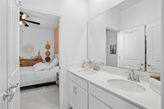 ensuite bathroom featuring double vanity, a ceiling fan, a sink, and tile patterned flooring