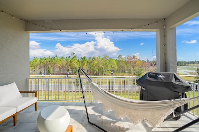 view of patio / terrace featuring area for grilling, fence, and a balcony