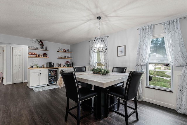 dining area with a chandelier, a textured ceiling, beverage cooler, and dark wood-type flooring