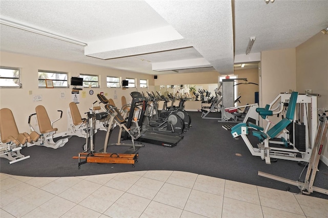 exercise room with light tile patterned floors and a textured ceiling