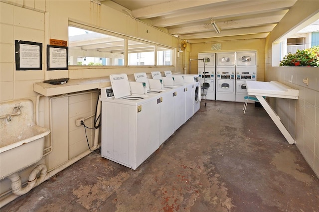 laundry room with washer and clothes dryer, stacked washer and clothes dryer, and sink