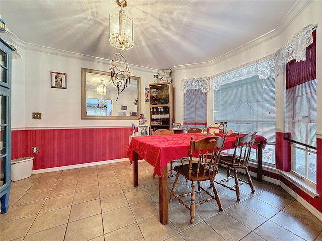 tiled dining room with ornamental molding, a textured ceiling, and a notable chandelier