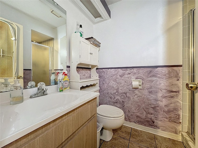 bathroom with tile patterned flooring, vanity, toilet, and a shower with door