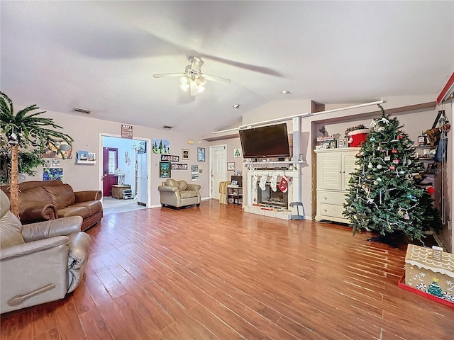 living room with wood-type flooring, ceiling fan, and lofted ceiling