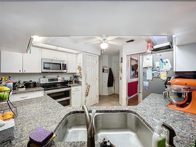 kitchen with white cabinetry, sink, ceiling fan, stainless steel appliances, and light tile patterned flooring