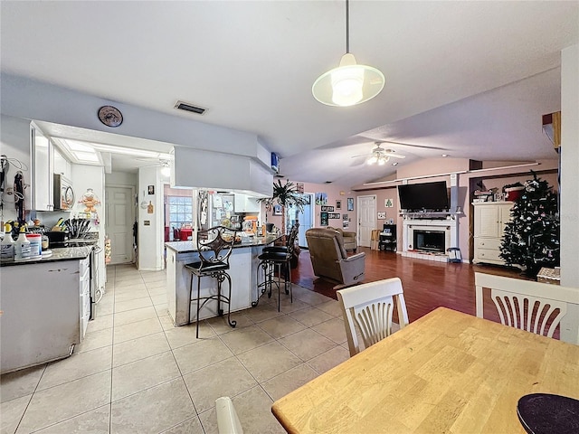 dining area featuring light tile patterned floors, ceiling fan, and lofted ceiling