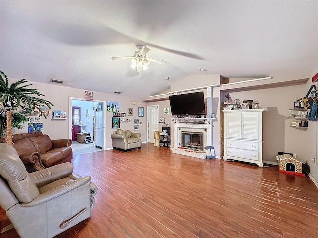 living room with hardwood / wood-style flooring, ceiling fan, and lofted ceiling