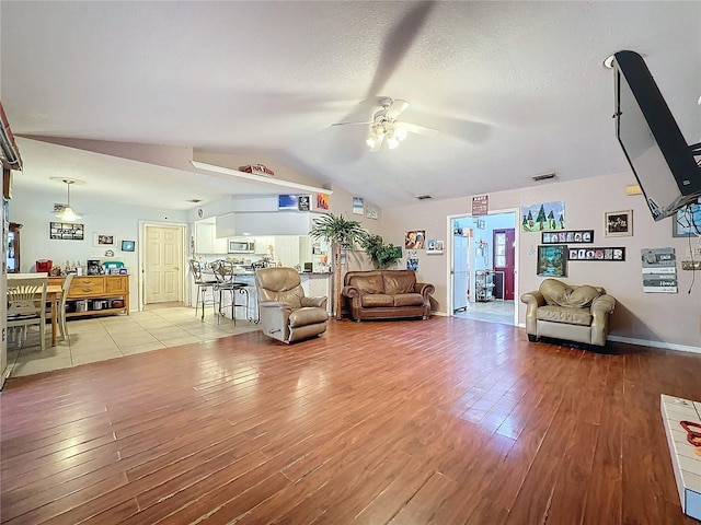 living room with light hardwood / wood-style flooring, ceiling fan, and lofted ceiling