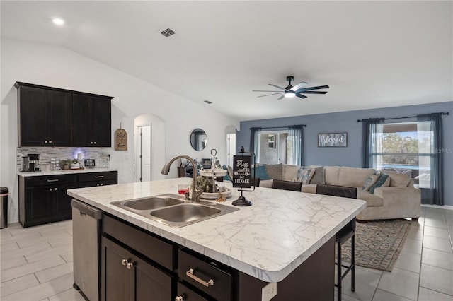 kitchen featuring ceiling fan, dishwasher, sink, vaulted ceiling, and a kitchen island with sink