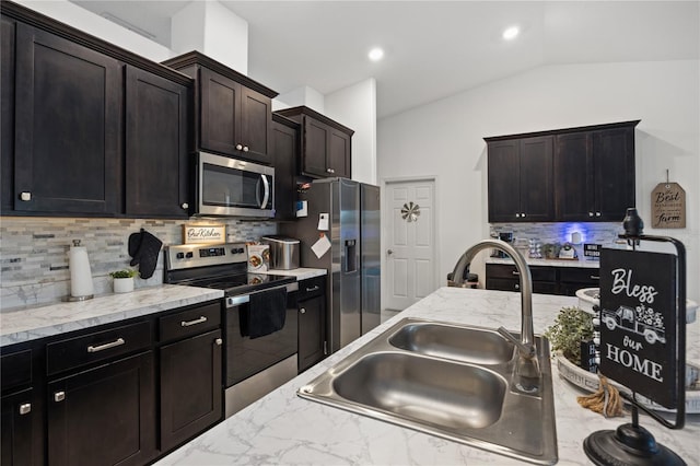 kitchen featuring backsplash, sink, vaulted ceiling, dark brown cabinetry, and stainless steel appliances