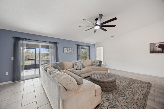 living room featuring a wealth of natural light, lofted ceiling, and ceiling fan