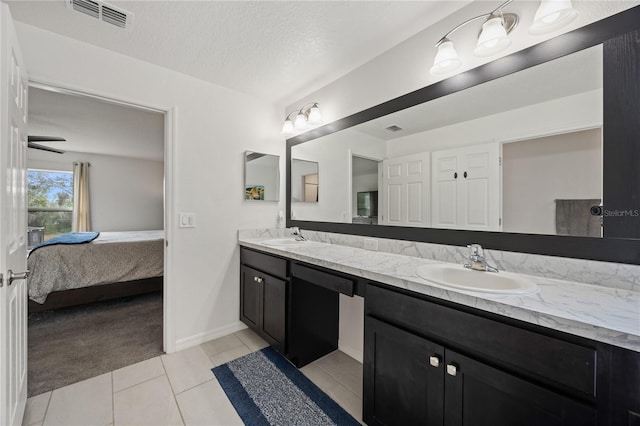 bathroom featuring tile patterned floors, vanity, and a textured ceiling