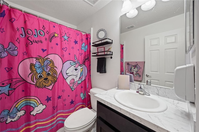 bathroom featuring vanity, toilet, and a textured ceiling