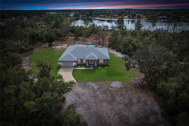 aerial view at dusk featuring a water view