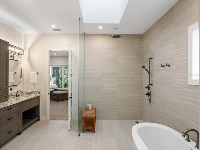 bathroom featuring vanity, independent shower and bath, and a skylight