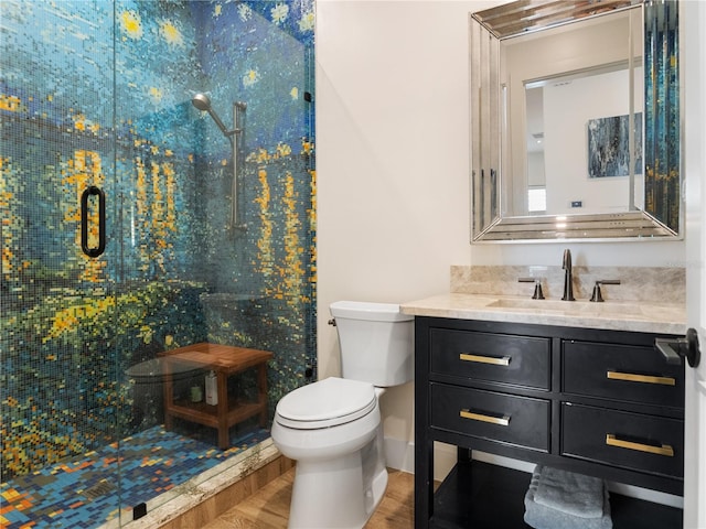 bathroom with hardwood / wood-style floors, vanity, toilet, and walk in shower