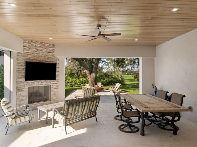 view of patio with an outdoor living space with a fireplace and ceiling fan