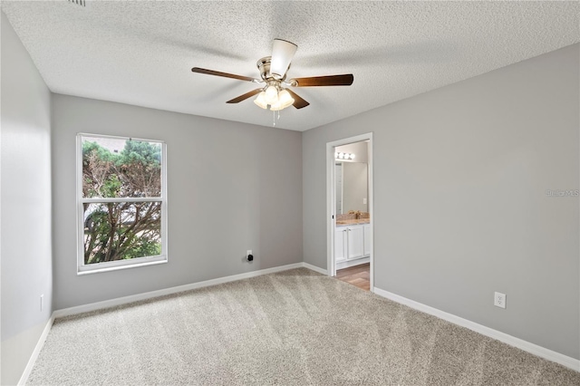 empty room featuring a textured ceiling, ceiling fan, and light carpet