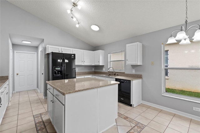 kitchen with vaulted ceiling, black appliances, white cabinets, a kitchen island, and light tile patterned flooring