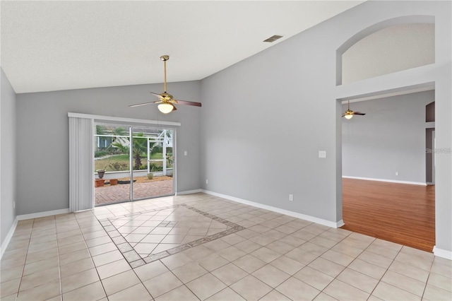 tiled spare room with ceiling fan and vaulted ceiling